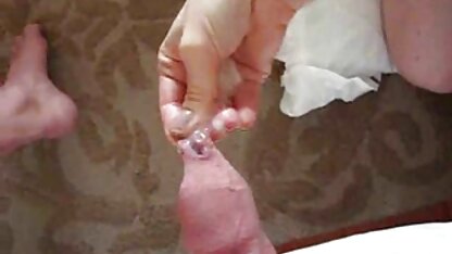Frau reife dame sex in einer rosa Perücke saugt einen Gummi-Schwanz in Sahne